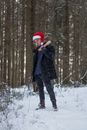 Man in Black Jacket and Red Knit Cap Standing on Snow Covered Ground