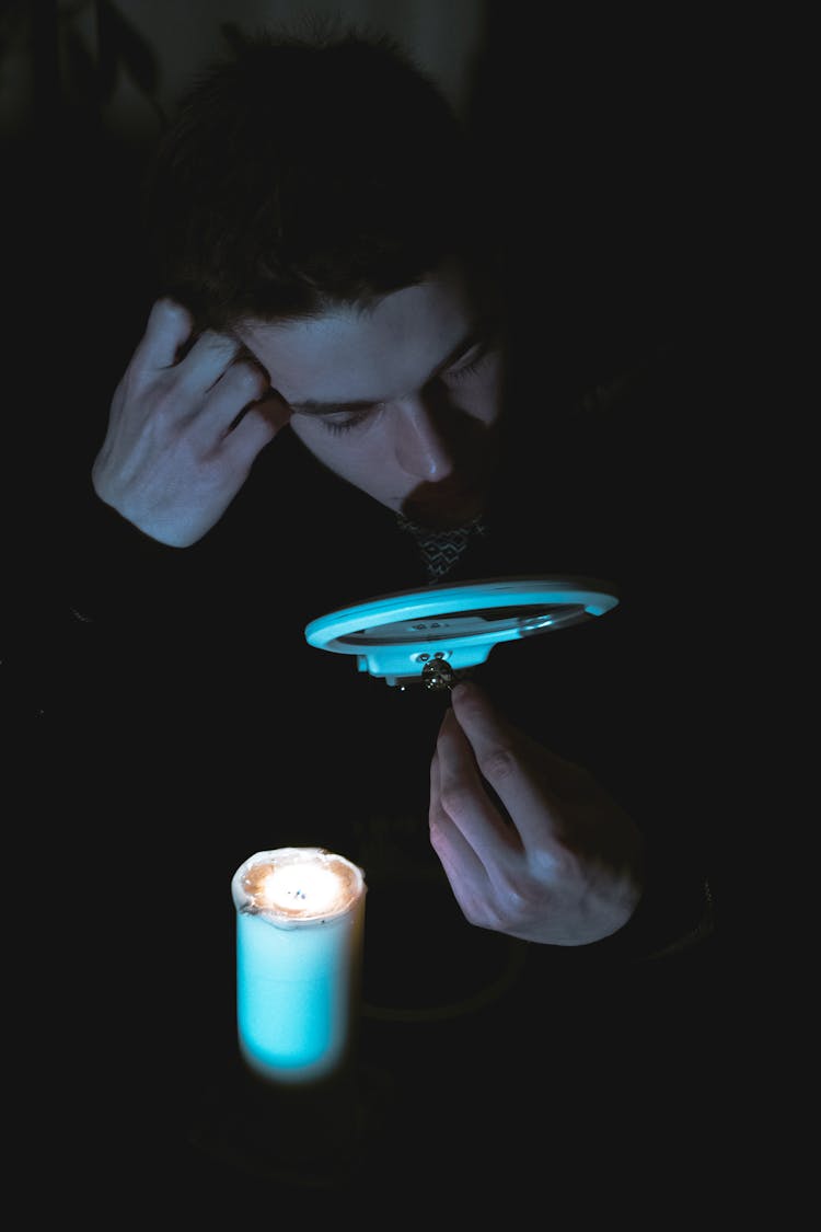 Man Holding Item Near Face