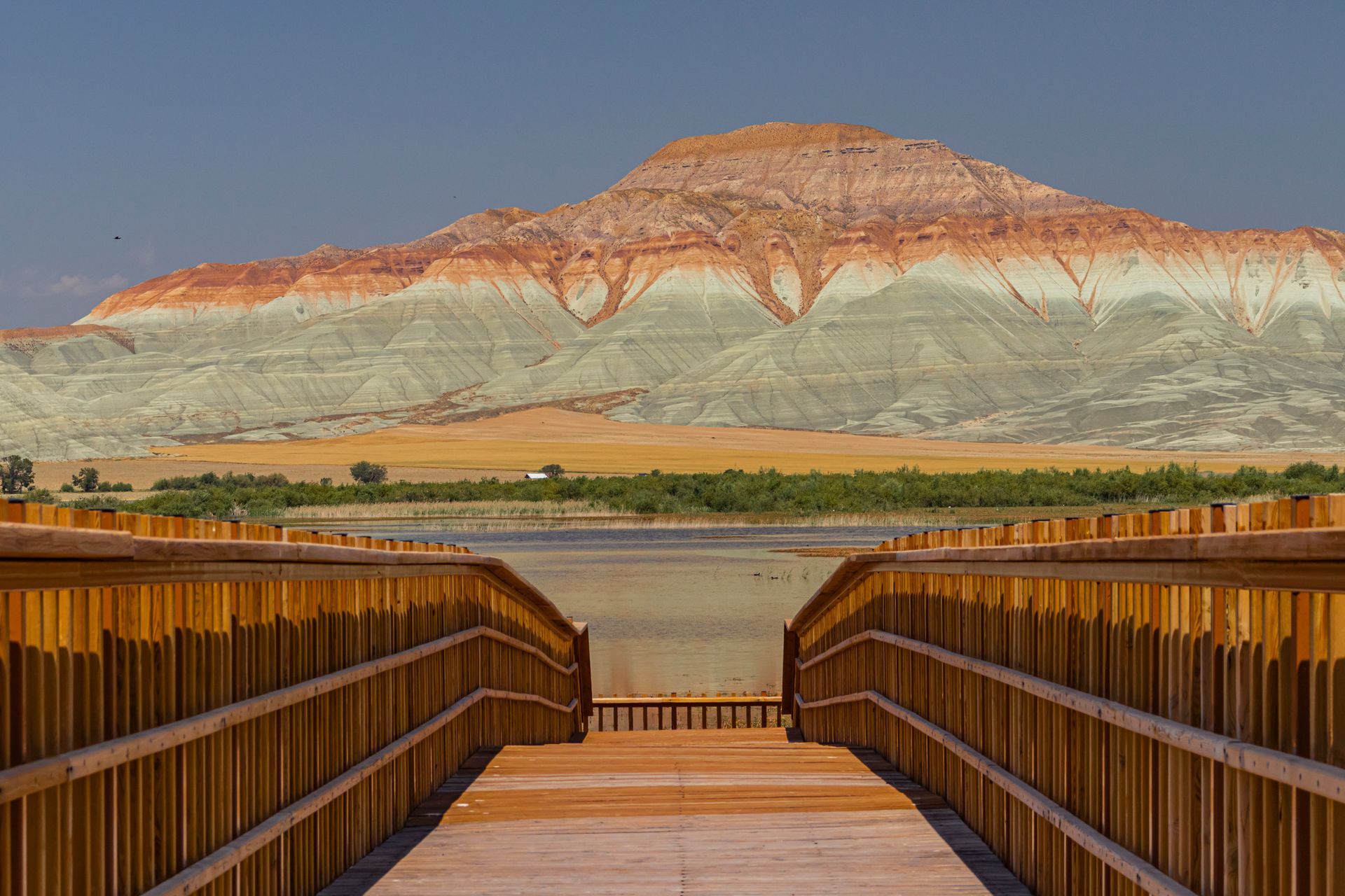 Stunning landscape of the Nallıhan Bird Sanctuary with a boardwalk leading to colorful mountains.