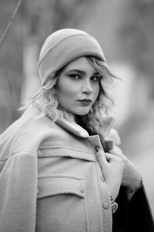 Grayscale Photo of Woman Wearing a Coat and Knit Cap