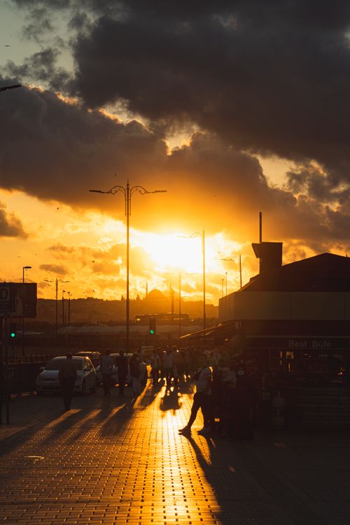 Free Captivating sunset casting golden hues over a bustling street scene. Stock Photo