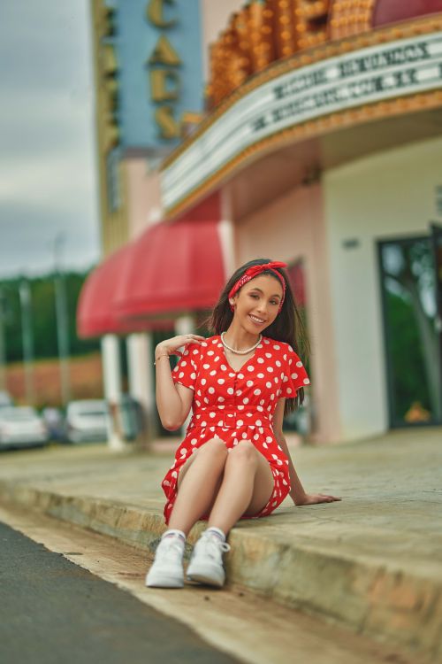 A Woman in a Red Polka Dot Dress Holding a Coke Can · Free Stock Photo