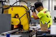 Man in Yellow T-shirt Holding Black and Gray Power Tool