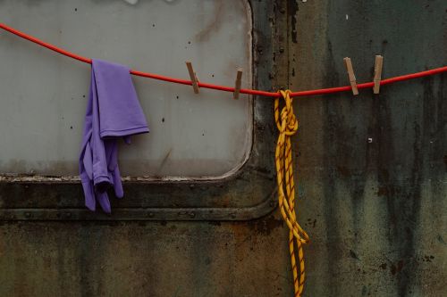 Free A rustic scene with clothespins, rope, and a worn wall. Vibrant colors and textures. Stock Photo