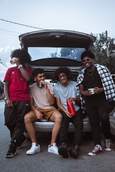 A group of friends enjoying a casual moment by an open car trunk in Brazil.