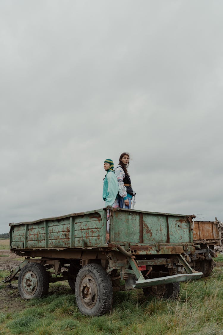 People On Rusty Truck Wagon Standing Back To Back 