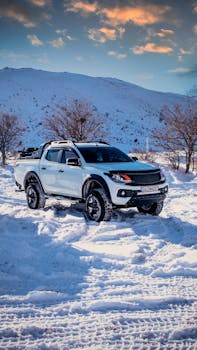A rugged SUV navigates through a snowy landscape in Kayseri, Türkiye, against a mountain backdrop.