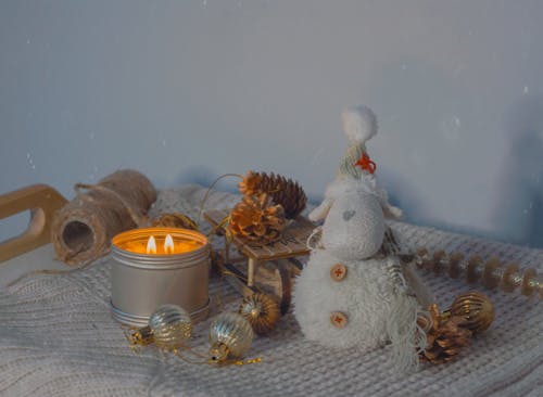 Free Christmas Decorations beside a Lighted Scented Candle Stock Photo