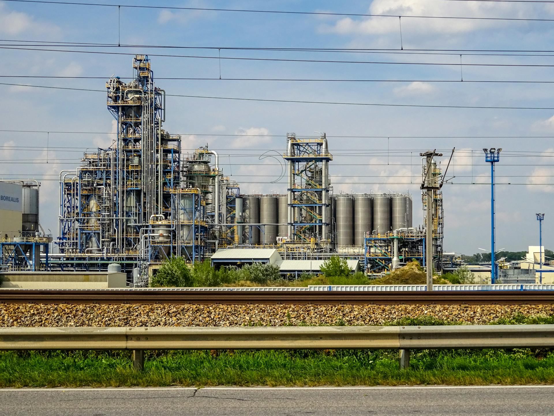 Image of a large chemical factory in Schwechat, Austria, showcasing industrial pipes and machinery.