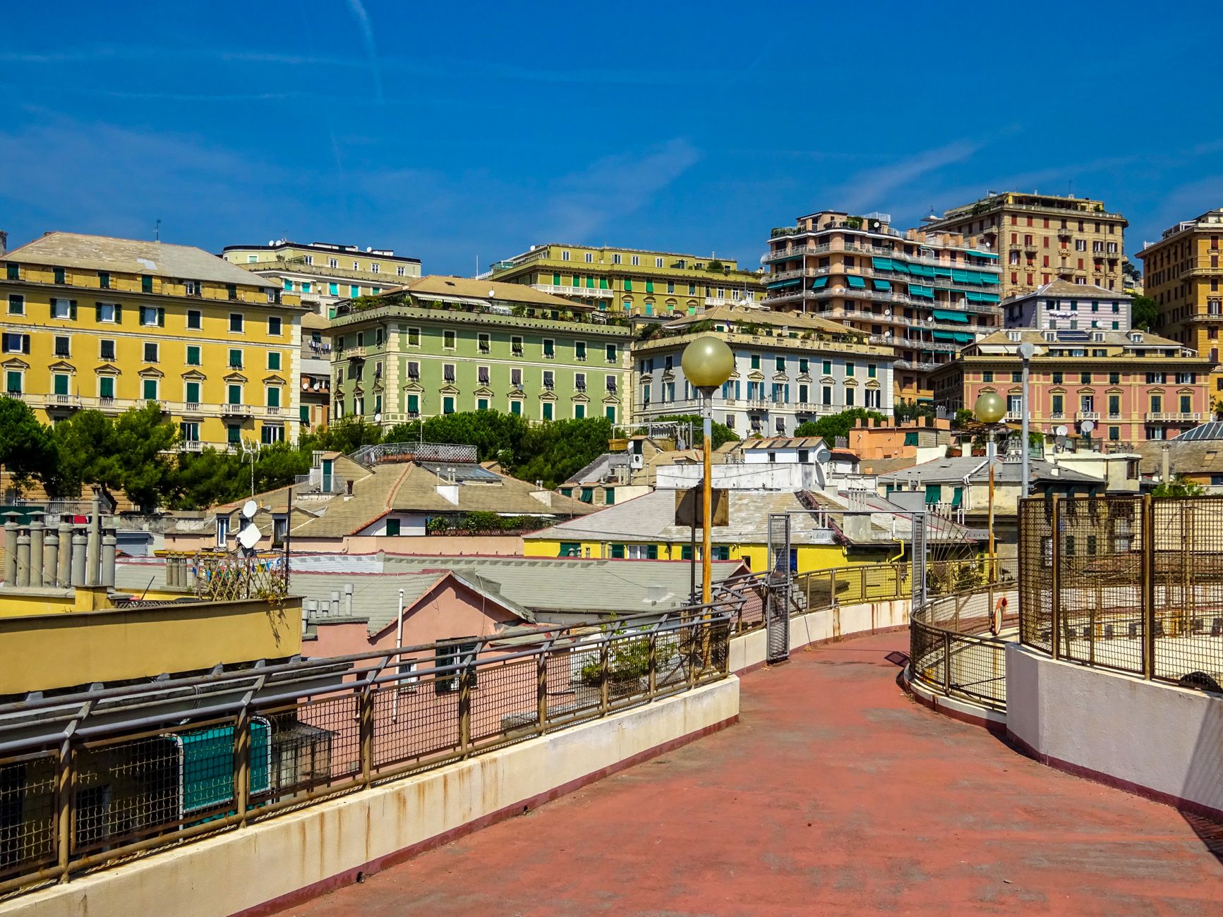 Vibrant residential buildings in Genoa, Italy under a clear blue sky.