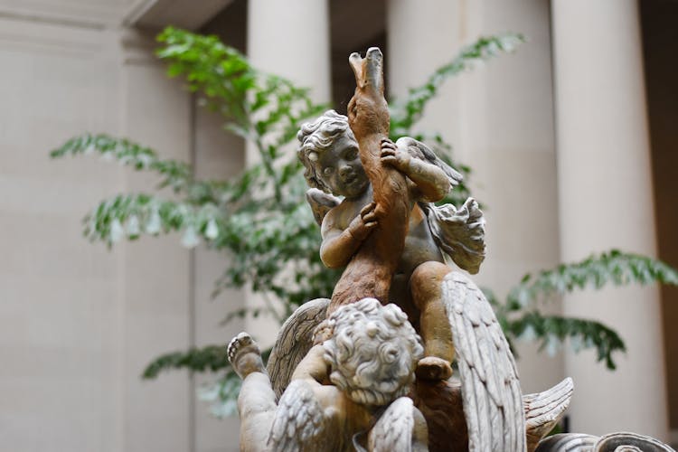 Brown Angel Statue Near Green Plant