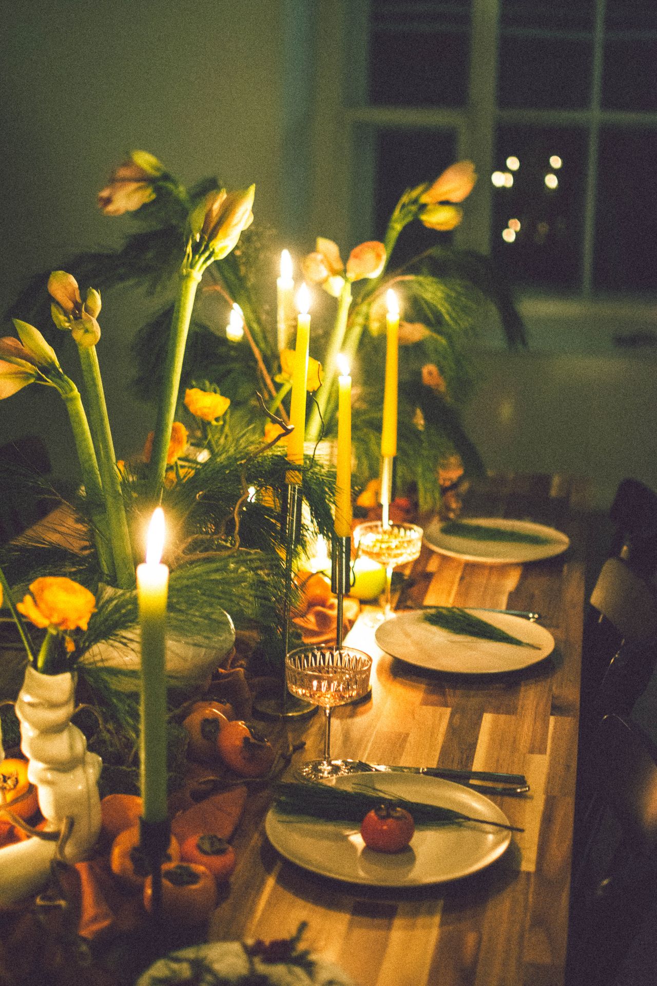Beautiful candlelit dinner setting with floral arrangements and tableware creating a warm ambiance.