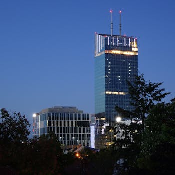 A towering skyscraper in Gdańsk, Poland, lit up against the night sky.