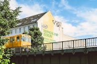 在一个阳光明媚的日子，一列黄色火车驶过德国柏林的一栋建筑