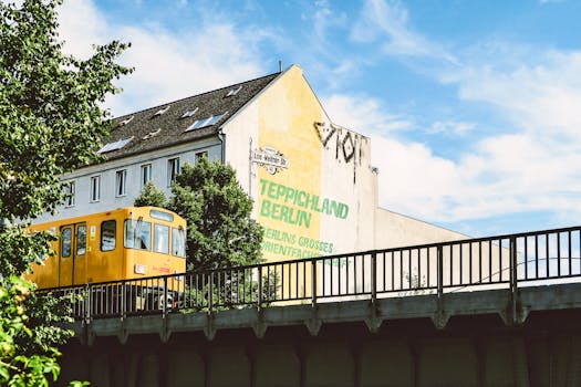 在一个阳光明媚的日子，一列黄色火车驶过德国柏林的一栋建筑