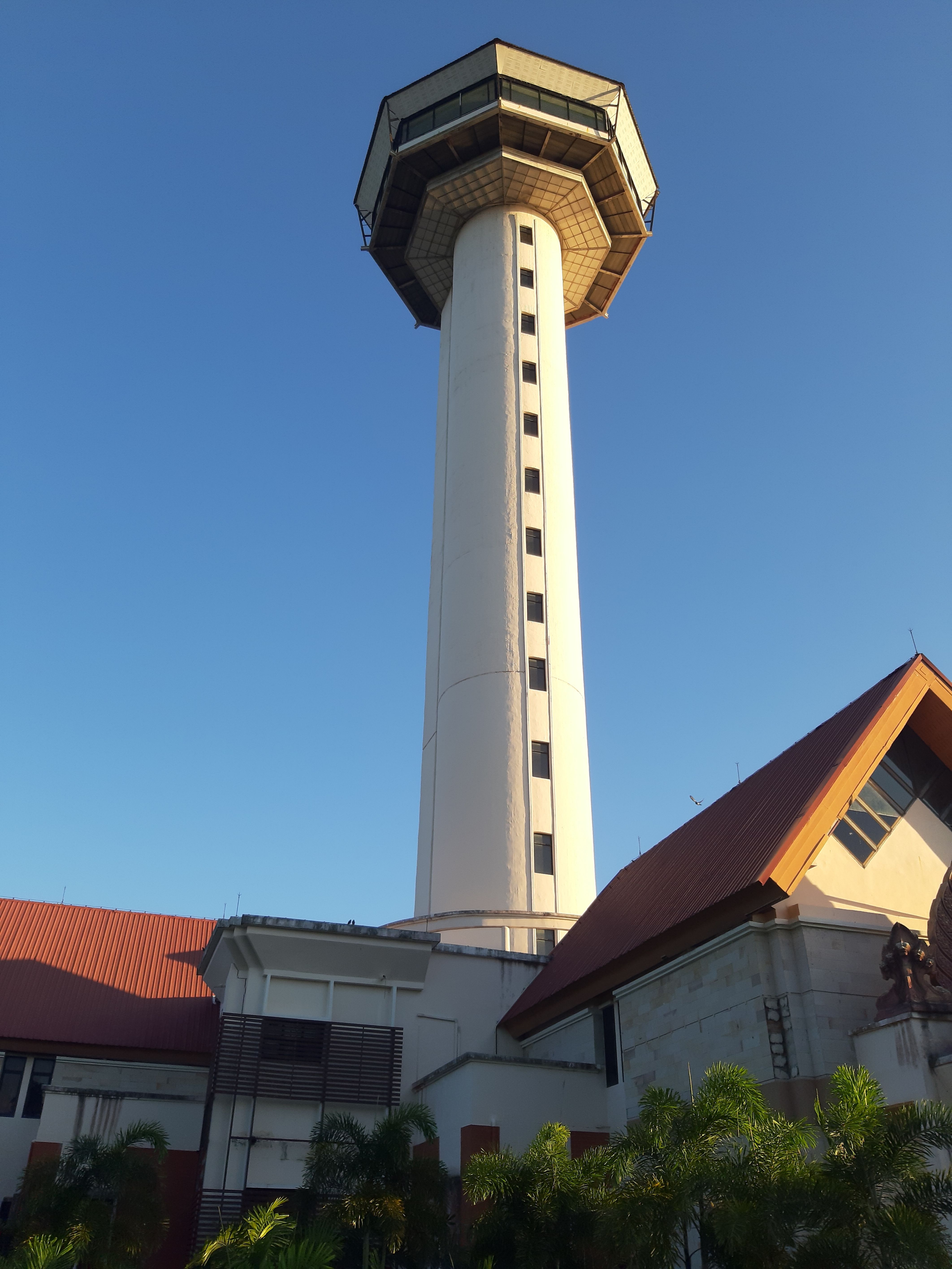 A vertical shot of the iconic Si Saket Tower in Mueang Tai, Thailand against a clear blue sky.