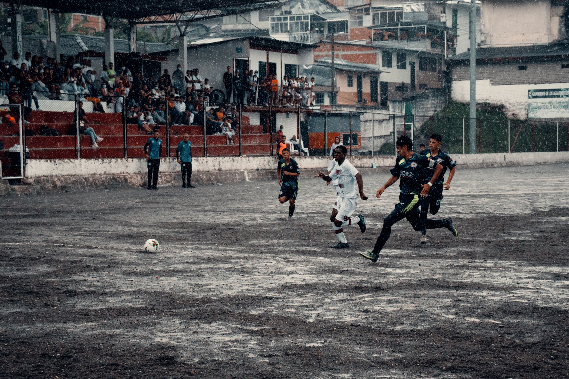 Exciting soccer game in Neira, Colombia, capturing athletes in action during a rainy match.