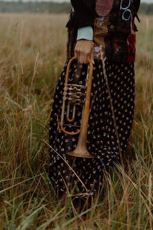 Woman Hand Holding Trumpet on Grassland