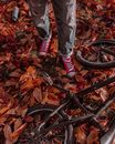 Person in Gray Denim Jeans Standing Beside Black Bicycle