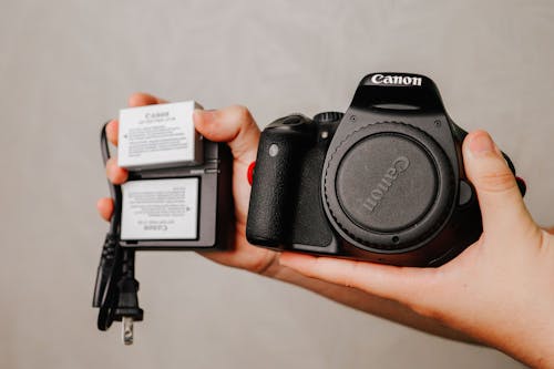 Free Photo of a Black Canon Camera with a Charger Stock Photo