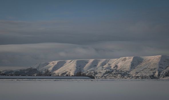 Breathtaking view of snow-covered mountains under a cloudy winter sky.