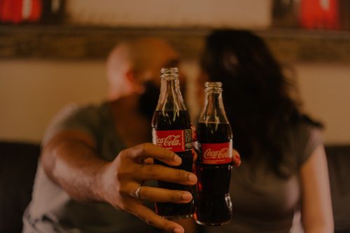 Free A couple sharing a moment with Coca-Cola, highlighting togetherness and love. Stock Photo