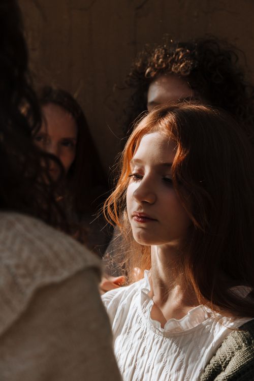 Free A serene portrait of a young redhead woman in soft sunlight, highlighting her tranquility. Stock Photo