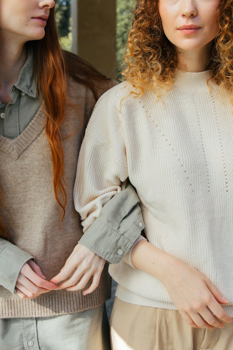 Mid Section Of Two Female Friends Arm In Arm