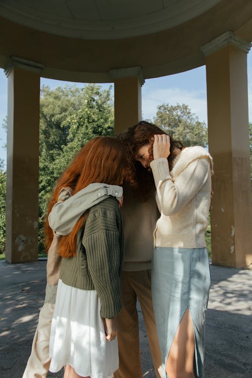 Four Female Friends Embracing and Sharing Secrets