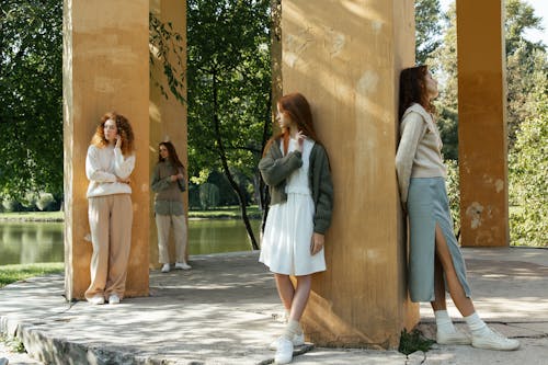 Four Female Friends Standing by Columns in Park