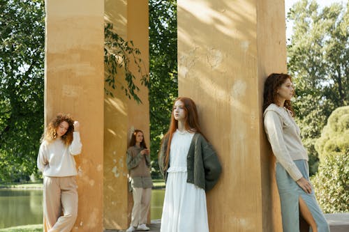 Free Four Pensive Women Standing by Columns in Park Stock Photo