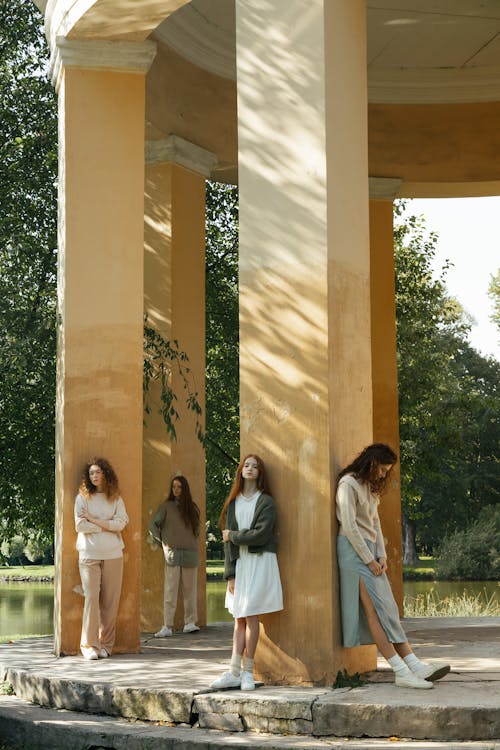 Four Female Friends Standing by Columns in Park