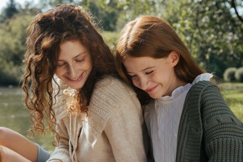 Free A mother and daughter share a joyful moment in a serene park setting, enjoying nature and each other's company. Stock Photo