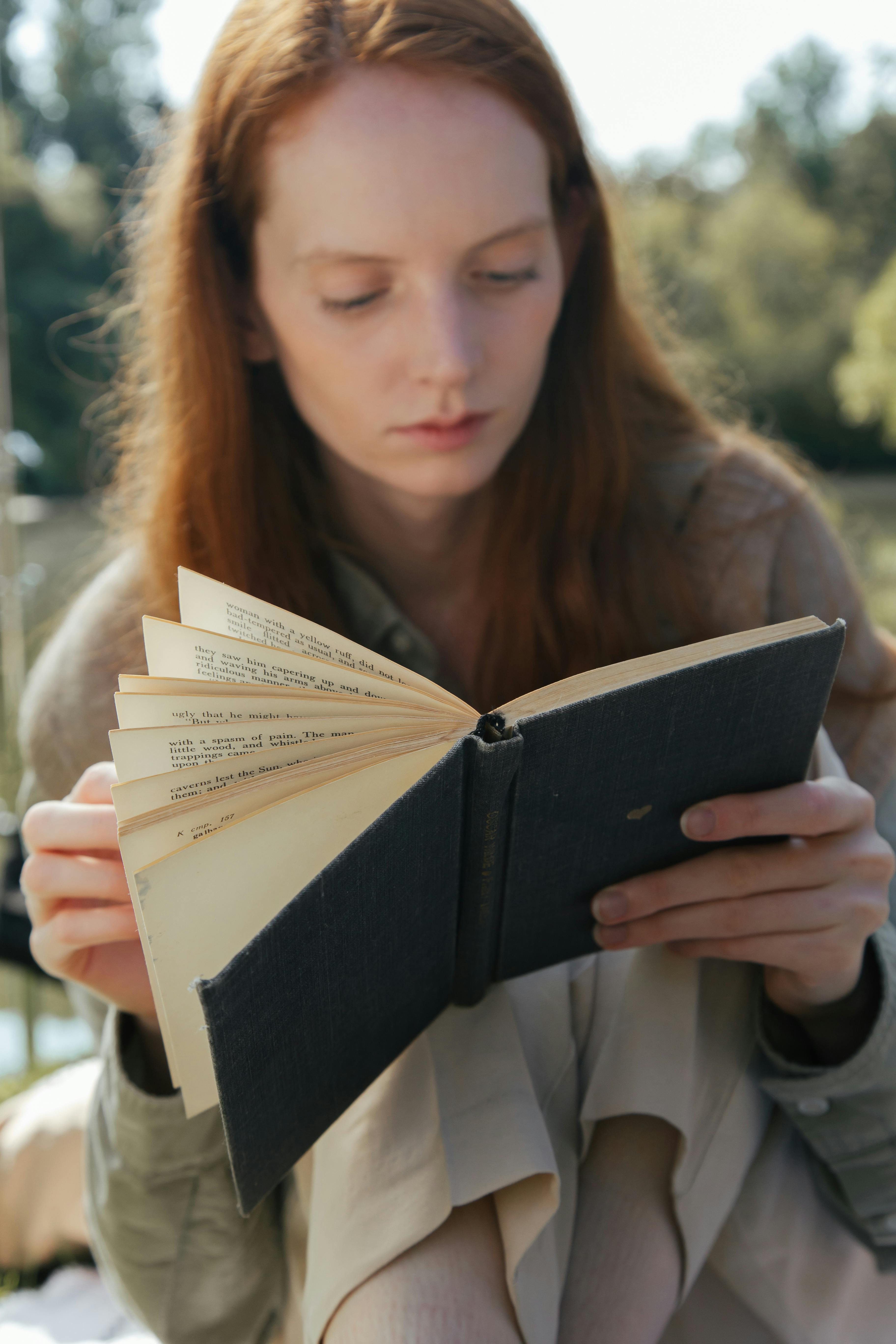 woman reading a book in a park