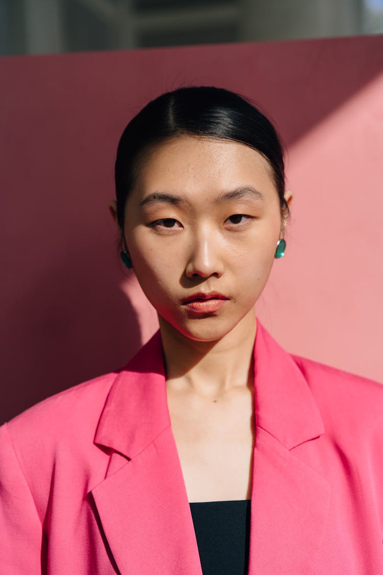 Woman In Pink Blazer And Green Earrings