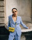 Woman in Blue Blazer Standing Against a Fountain
