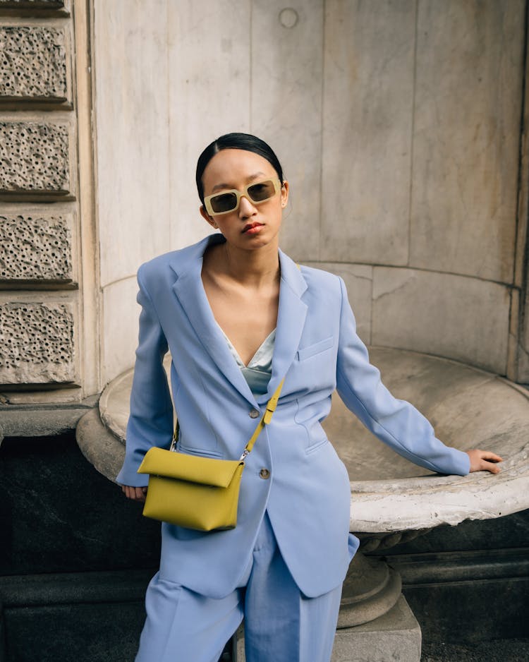 Woman In Blue Blazer Standing Against A Fountain