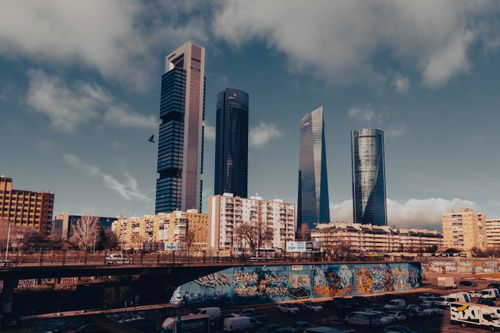 Free Stunning view of Madrid's skyscrapers with urban graffiti foreground, capturing modern architecture. Stock Photo