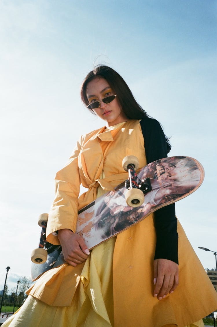 Woman Wearing Yellow Dress Holding A Skateboard