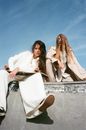 Women in White Clothes Sitting on Skate Ramp