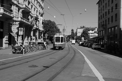 Grayscale Photo of a Tram Travelling the Street