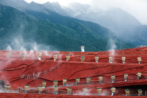 People Standing on Red Wall Carrying Baskets on their Backs