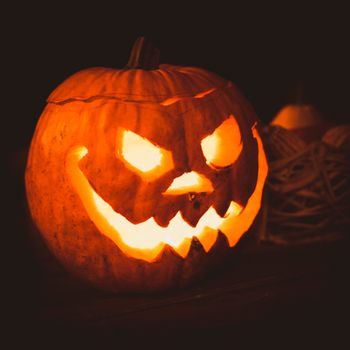A carved pumpkin with a creepy face illuminated for Halloween night, creating a spooky atmosphere.（イメージ）