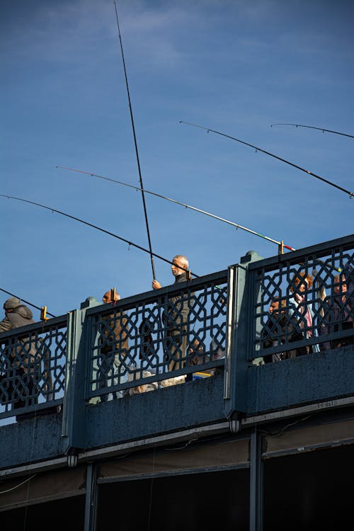 A Person Standing on a Bridge Holding a Fishing Rod