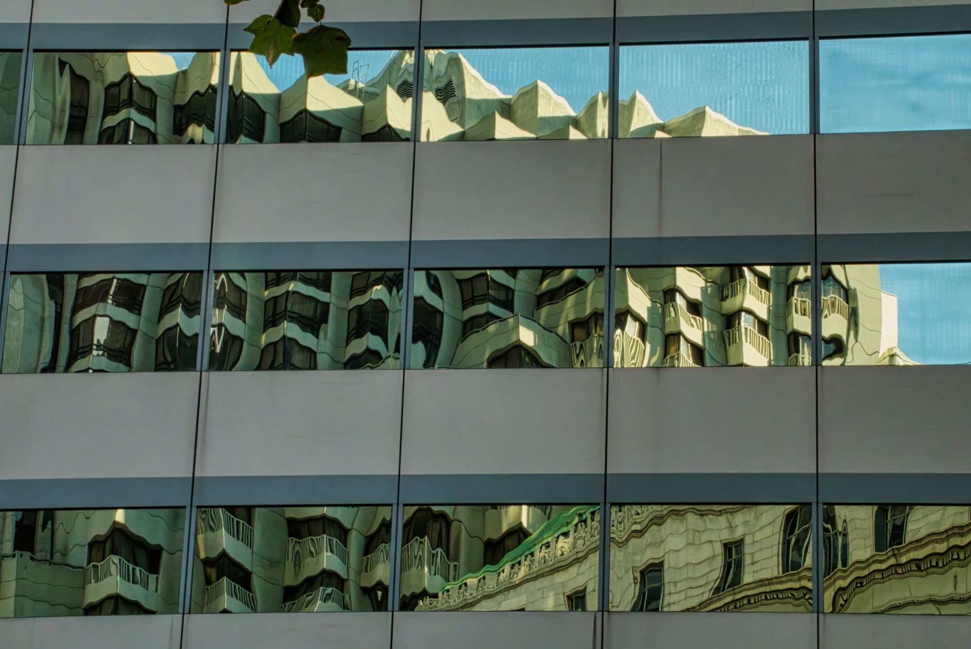 Cityscape reflection on building facade windows in San Francisco, CA.