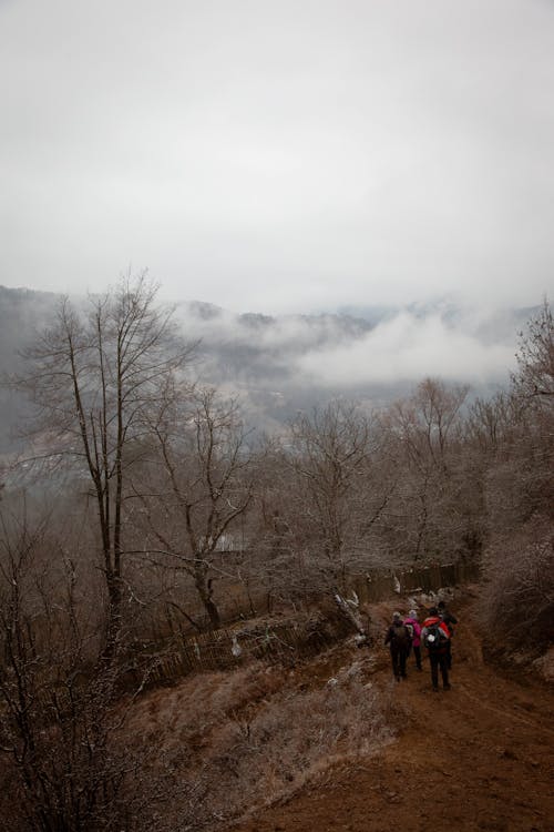 People Hiking in Mountains in Fog