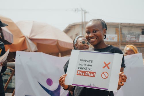 A Woman Smiling Holding a Poster