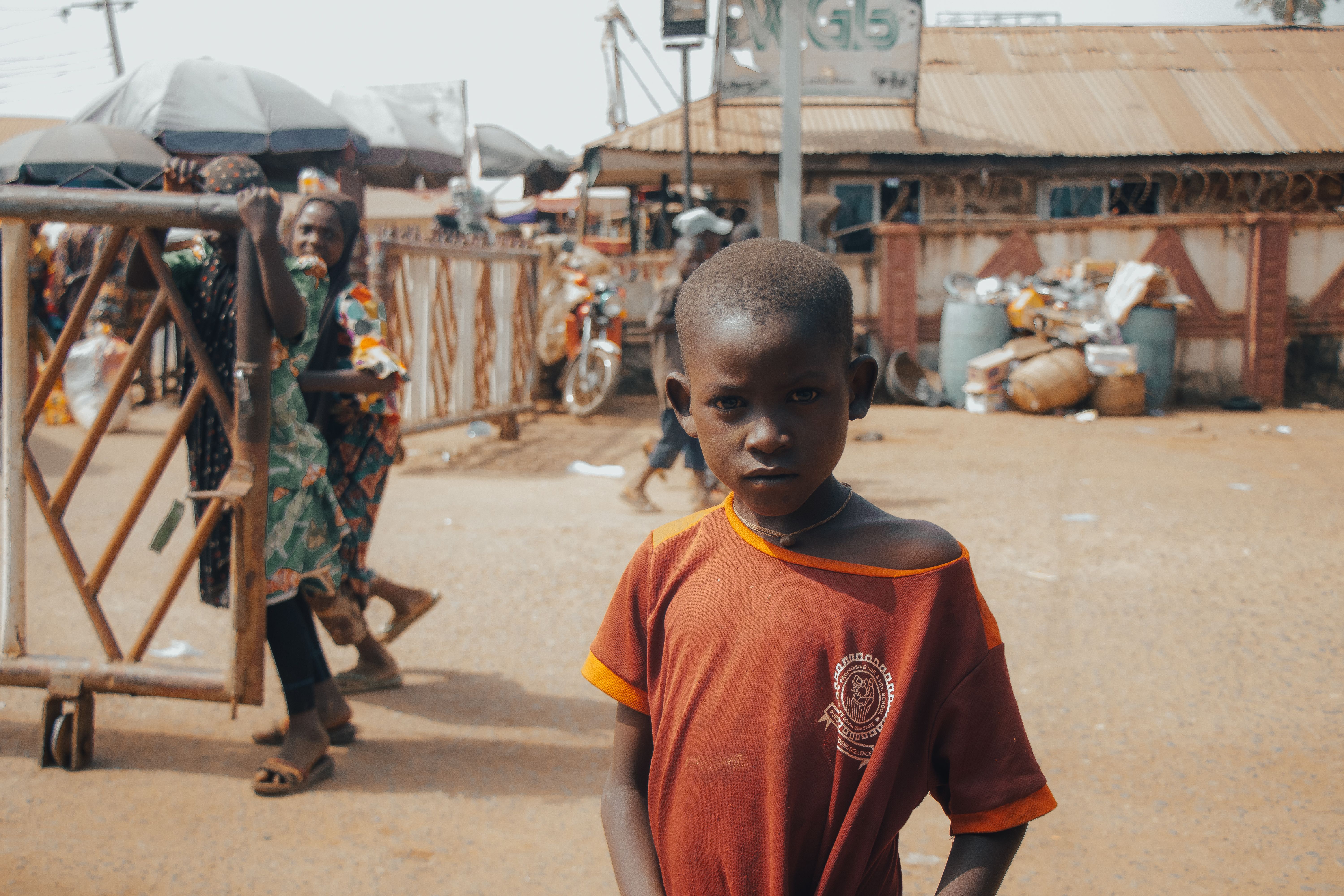 Un petit garçon au marché du village, en tenue d'écolier