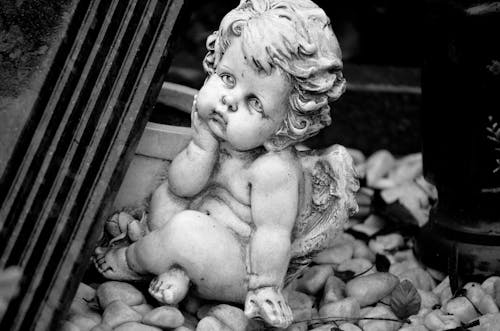 A Grayscale of a Statue of a Baby Angel