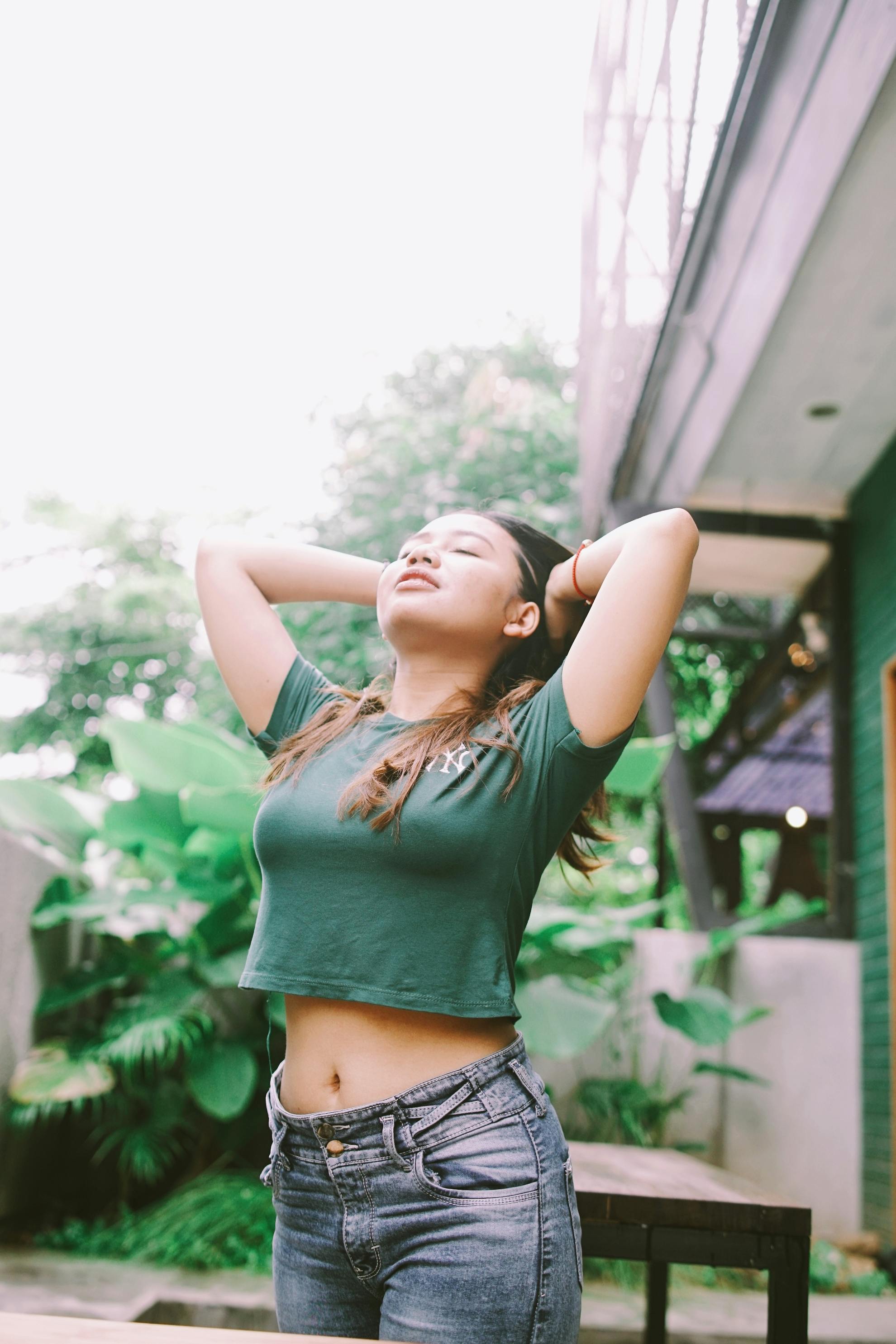 A Woman Wearing a Crop Top and Denim Pants · Free Stock Photo